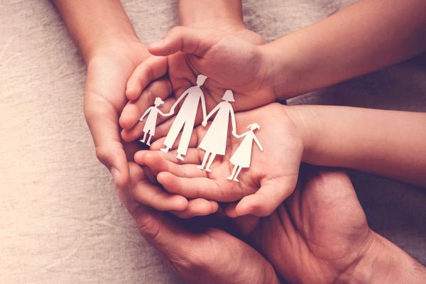 image de mains d'enfants et parents portant une famille unie en papier, représentant le soutien familial