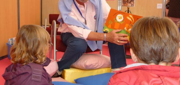 photo d'un homme assurant la lecture à des enfants 