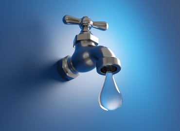 Photo d'un robinet avec une goutte d'eau qui est prête à tomber